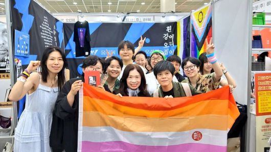 ‘2025 서울국제도서전’에 퀴어 출판사 3곳(화이트 리버, 오리집, 움직씨)이 연합해 차린 M19 부스에 천쉐(왼쪽 네번째) 작가와 동성 배우자 짜오찬런(왼쪽 다섯번쨰)이 방문해 기념촬영을 하고 있다. 움직씨 제공