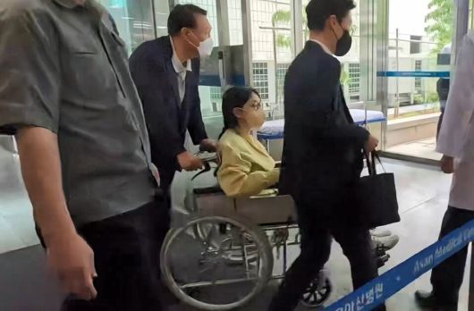윤석열 전 대통령의 부인 김건희씨가 6월27일 서울 송파구 서울아산병원에서 윤 전 대통령이 미는 휠체어에 탄 채 퇴원하고 있다. 연합뉴스