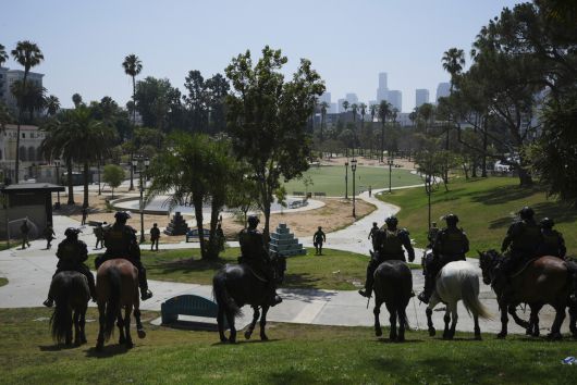 중무장한 연방 요원들이 말을 타고 7일(현지시각) 미국 캘리포니아주 로스앤젤레스시 맥아더 공원에서 미등록 이민자 단속 활동을 하고 있다. AP 연합뉴스