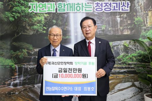 최봉호(왼쪽) 전 충남대 교수가 지난해 4월 충북 괴산군을 찾아 송인헌 괴산군수에게 장학금 1천만원을 건넸다. 괴산군 제공