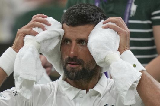 노바크 조코비치가 지난 2일(한국시각) 윔블던 남자 단식 1라운드가 끝난 뒤 차가운 수건을 머리에 두르며 더위를 식히고 있다. 런던/AP 연합뉴스
