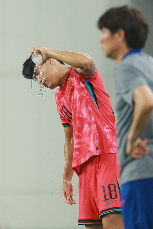 남자축구 대표팀 이호재가 지난 7일 경기 용인 미르스타디움에서 열린 2025년 동아시아축구연맹(EAFF) E-1 챔피언십 중국과 경기에서 교체 투입을 기다리며 얼굴에 물을 뿌려 더위를 식히고 있다. 연합뉴스