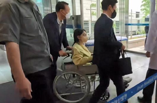 윤석열 전 대통령의 부인 김건희씨가 6월27일 서울 송파구 서울아산병원에서 윤 전 대통령이 미는 휠체어에 탄 채 퇴원하고 있다. 연합뉴스