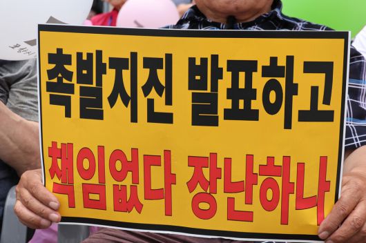 경북 포항 지진 정신적 손해배상 소송의 항소심 패소 판결과 관련해 ‘포항지진 범시민대책본부’가 지난달 13일 포항 육거리 인근 중앙상가에서 개최한 시민궐기대회에서 시민들이 항의 손팻말을 들고 있다. 연합뉴스