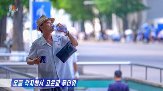 북한이 지난 8일부터 무더위 주의경보를 발령한 가운데 평양 시민이 물을 마시며 더위를 식히고 있다. 조선중앙티브이(TV) 화면 갈무리
