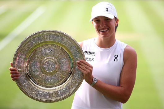 이가 시비옹테크(폴란드)가 12일(현지시각) 영국 런던 올 잉글랜드 클럽에서 열린 윔블던 여자 단식 결승에서 어맨다 아니시모바(미국)를 꺾은 뒤 우승 트로피를 들고 환하게 웃고 있다. 런던/AFP 연합뉴스