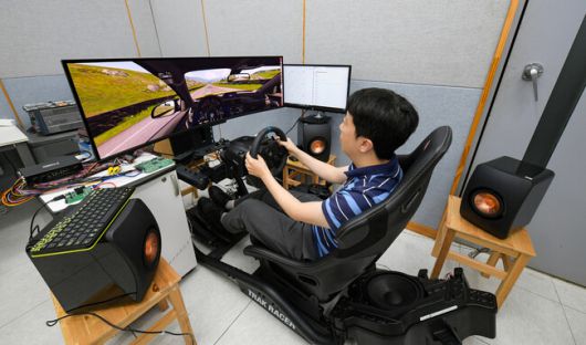 박정식 현대모비스 음향로직팀 책임연구원이 지난달 25일 경기 용인시 기술연구소에서 플레이스테이션 레이싱 게임을 하며 직접 개발한 가상 엔진음을 들어보고 있다. 현대모비스 제공