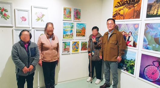 서울시 주최로 지난해 11월 덕수궁 인근 ‘스페이스 소포라’에서 열린 ‘희망의 인문학 수료생 전시회’에서 작품을 출품한 동자동 주민들과 기념사진을 찍는 모습. 서울역쪽방상담소 제공