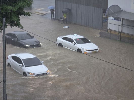 호우경보가 발효된 17일 광주 북구 용봉동 북구청사 앞 도로가 침수돼 차량이 멈춰서있다. 연합뉴스