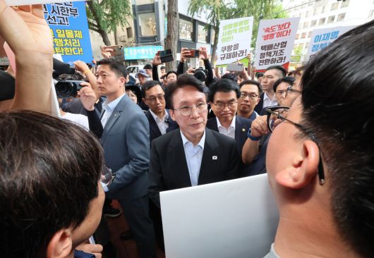 22일 서울 중구 민주노총을 찾은 김민석 국무총리가 위원장실로 향하던 중 민주노총 조합원들의 이야기를 듣고 있다. 연합뉴스