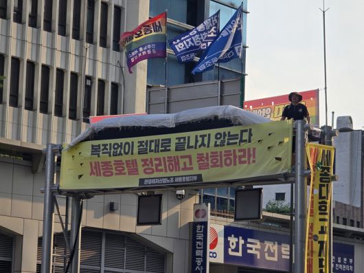 25일 서울 중구 세종호텔 앞 교통구조물 위에서 고공농성 중인 고진수 민주노총 세종호텔지부장. 남지현 기자