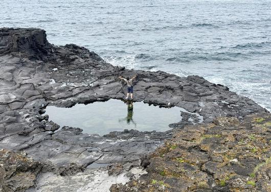제주 신도2리 마을에 있는 ‘도구리와 모살물’. 도구리에 비친 여행객의 모습이 색다른 사진을 연출한다. 박미향 기자