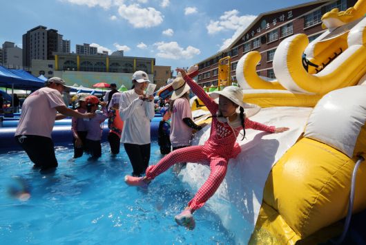 전국적으로 폭염이 이어진 27일 오후 서울 성북구 숭덕초등학교에 마련된 성북문화바캉스 물놀이장에서 시민들과 어린이들이 즐거운 시간을 보내고 있다. 김태형 기자 xogud555@hani.co.kr