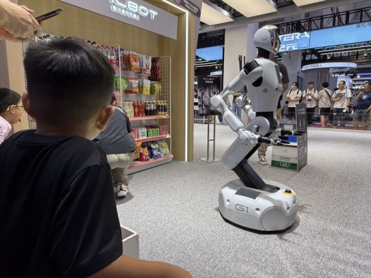 진열대에서 과자를 나르는 로봇을 관람하는 어린이들. 베이징/이정연 특파원