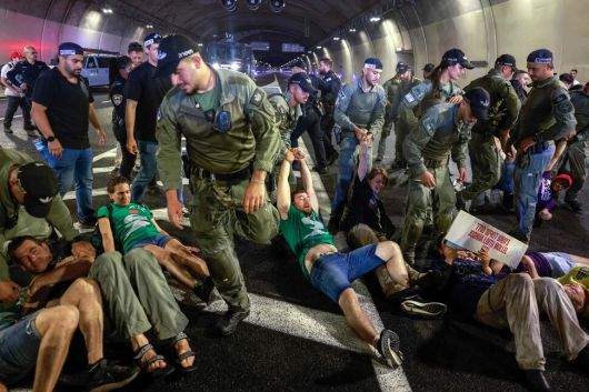 17일(현지시각) 이스라엘 예루살렘 한 터널 안에서 경찰이 시위대를 끌어내고 있다. 이날 이스라엘 전역에서 가자 전쟁 종식과 인질 석방을 위한 대규모 시위가 진행됐다. 예루살렘/AFP 연합뉴스