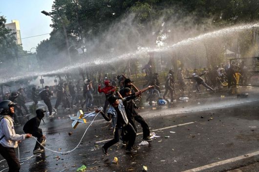 29일, 인도네시아 수라비야에 있는 동자바 주지사 관저 앞에서 오토바이 배달기사 사망 사건에 항의하는 시위대를 향해 경찰이 물대포를 쏘고 있다. 수라바야/AFP 연합뉴스