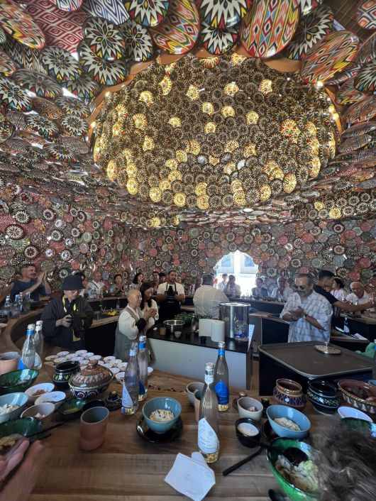 지난달 9일 수보드 굽타 작가의 식기 설치 공간에서 정관 스님이 음식들을 차려놓고 합장하면서 예를 올리고 있다. 스님 오른쪽에 선글라스를 끼고 두 손을 모은 이가 수보드 굽타다. 오경순씨 제공