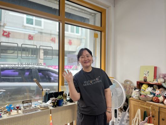 광주 북구 오치동에 있는 마을 에너지전환 거점센터 ‘문산돌돌에너지센터’ 김희련 공동대표가 센터 내 제로 웨이스트 전시장 앞에서 손을 흔들고 있다.