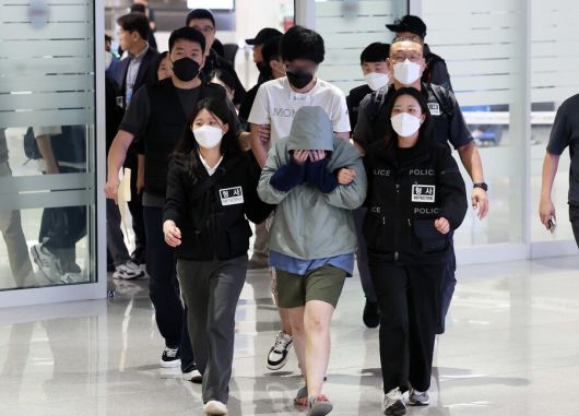 캄보디아 당국의 범죄단지 단속으로 적발돼 구금됐던 한국인 64명이 18일 오전 인천국제공항 2터미널을 통해 송환되고 있다. 이들은 호송 차량 23대 등을 타고 충남경찰청 등 6개 관할 경찰관서로 압송됐다. 공동취재사진