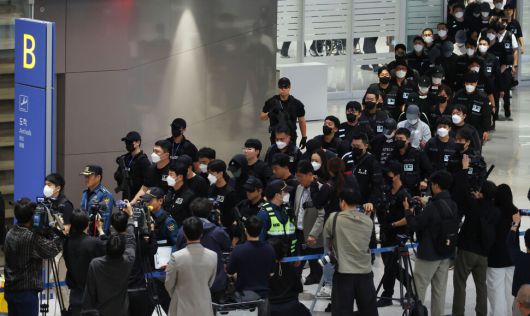 캄보디아에서 보이스피싱(전화금융사기) 등 범죄에 가담했다가 현지 경찰 조사를 받고 이민 당국에 구금됐던 한국인 64명이 18일 오전 인천국제공항 제2터미널을 통해 송환되고 있다. 공동취재사진