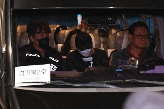 캄보디아 온라인 사기에 가담해 구금됐던 한국인들이 18일 오전 인천국제공항 제2터미널을 통해 송환돼 각 경찰서로 가는 호송차량에 탑승해 있다. 공동취재사진