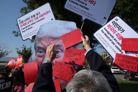 국제민중행동 조직위원회가 29일 오전 경북 경주시 보문단지 통제구역 앞에서 연 ‘트럼프 방한 규탄! 기자회견’에서 한 참가자가 트럼프 형상에 레드 카드를 붙이고 있다. 최현수 기자 emd@hani.co.kr