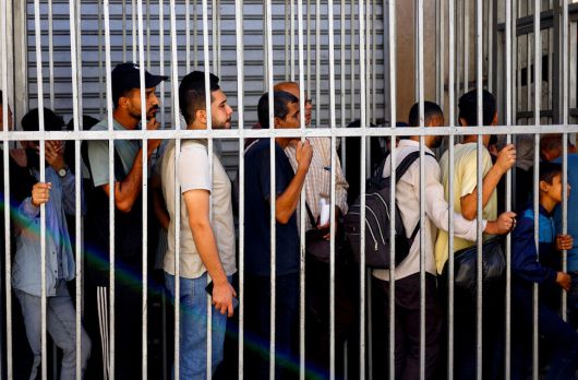 31일(현지시각) 팔레스타인 가자지구 중부 누세이라트에서 팔레스타인 주민들이 팔레스타인은행 밖에서 줄을 서 기다리고 있다. 로이터 연합뉴스