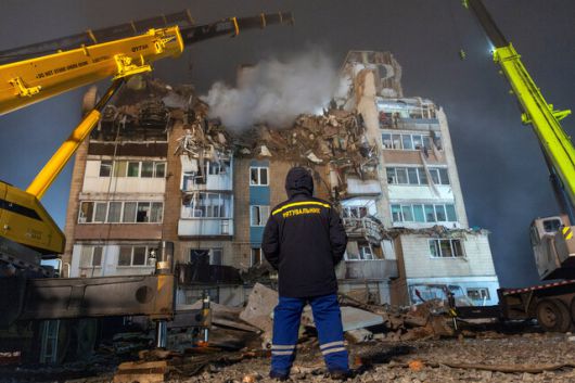 19일 러시아군 공습으로 파괴된 우크라이나 테르노필의 아파트 앞에 구조대원이 서 있다. 로이터 연합뉴스