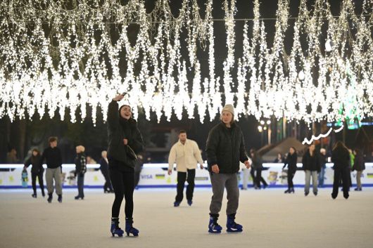 한 우크라이나 여성이 1일(현지시각) 키이우의 크리스마스 마켓 아이스링크에서 스케이트를 타며 셀카 사진을 찍고 있다. 키이우/AFP 연합뉴스