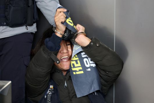 정성용 민주노총 공공운수노조 쿠팡물류센터지회 지회장이 10일 오후 서울 송파구 쿠팡 본사가 있는 건물에서 박대준 쿠팡 대표이사를 만나기 위해 승강기 탑승을 시도하다가 경찰에 체포된 뒤 수갑을 찬 채 구호를 외치고 있다. 김영원 기자 forever@hani.co.kr