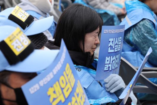 20일 오후 서울 종로구 보신각 광장에서 열린 1229 무안공항 제주항공 여객기 참사 1주기 서울시민추모대회에서 한 유가족이 손팻말을 들고 추모사를 듣고 있다. 김태형 기자