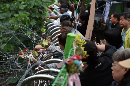 지난해 10월 경기도 동두천시 상봉암동 옛 성병관리소에서 동두천성병관리소 철거 저지를 위한 공동대책위원회(공대위) 주최로 철거에 반대하는 문화제가 열려 참가자들이 건물 들머리에서 ‘평화의꽃’을 꽂고 있다. ‘유령 연구’의 지은이 그레이스 조는 공대위의 천막 농성장에 두번 방문했다고 한국어판 서문에 썼다. 이종근 선임기자 root2@hani.co.kr