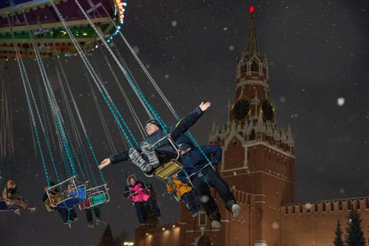 아이들이 25일 러시아 모스크바 붉은광장에서 크리스마스와 새해 축제를 맞아 꾸며진 크리스마스 장터의 회전 놀이기구를 타고 있다. 모스크바/AP 연합뉴스