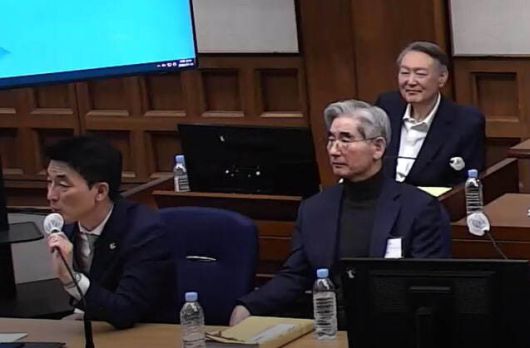 5일 열린 재판에서 이하상 변호사가 지귀연 재판장에게 발언하는 모습을 보며 윤석열 전 대통령이 뒷자리에서 웃고 있다. 서울중앙지법 제공