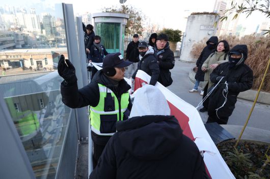 태안화력 고 김충현 비정규직 노동자 사망사고 대책위원회 관계자들이 7일 오전 서울 중구 서울로7017에서 이재명 정부에 한전케이피에스(KPS) 직접고용을 촉구하며 펼침막을 내거는 기습시위를 벌이자 서울로 보안관이 이를 제지하고 있다. 최현수 기자 emd@hani.co.kr