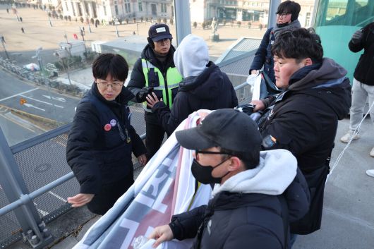 태안화력 고 김충현 비정규직 노동자 사망사고 대책위원회 관계자들이 7일 오전 서울 중구 서울로7017에서 이재명 정부에 한전케이피에스(KPS) 직접고용을 촉구하며 펼침막을 내거는 기습시위를 벌이자 서울로 보안관이 이를 제지하고 있다. 최현수 기자 emd@hani.co.kr