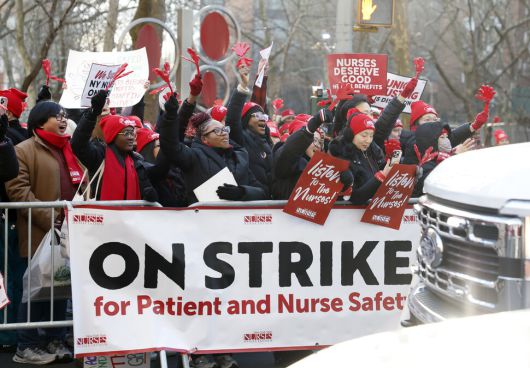 뉴욕주간호사협회 소속 조합원들이 지난 12일(현지시각) 맨해튼 마운트 시나이 병원 들머리에서 손팻말과 펼침막을 들고 있다. 뉴욕/UPI 연합뉴스