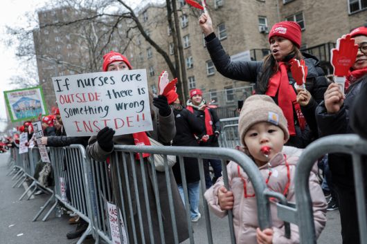 한 조합원이 지난 14일(현지시각) 뉴욕 맨해튼 마운트 시나이 병원 들머리에서 ‘간호사들이 밖에 있다는 건, 병원 안에 잘못된 일이 있다는 뜻’이라고 적힌 손팻말을 들고 있다. 뉴욕/로이터 연합뉴스