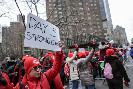 한 조합원이 지난 14일(현지시각) 뉴욕 맨해튼 마운트 시나이 병원 들머리에서 ‘파업 3일차, 더 강해졌다’라고 적힌 손팻말을 들고 있다. 뉴욕/로이터 연합뉴스