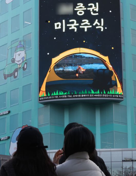 지난달 24일 기획재정부가 해외 주식을 팔고 국내 주식에 장기투자할 경우 해외 주식 양도소득세를 한시적으로 비과세하는 방안을 발표한 가운데, 서울 시내에 한 증권사 전광판에 미국 주식 광고가 나오고 있다. 연합뉴스