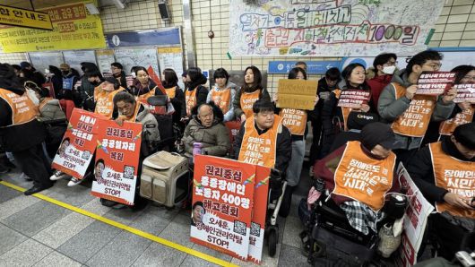 19일 오전 서울 종로구 혜화역 승강장에서 ‘열차가 어둠을 헤치고, 출근길 지하철 선전전 1000일’에 참석한 활동가·시민들이 손팻말을 들고 있다. 김수연 기자