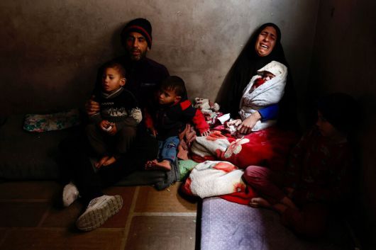 20일(현지시각) 가자지구 가자시티에서 저체온증으로 사망한 생후 3개월 샤자 아부 자라드의 가족들이 딸의 죽음을 슬퍼하고 있다. 샤자의 어머니 히바(30)가 샤자의 쌍둥이 남매 나다를 안고 있다. AFP 연합뉴스