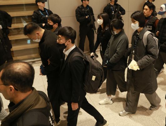 캄보디아에서 우리 국민 104명을 대상으로 120억원 상당을 가로챈 혐의를 받는 부부가 23일 오전 인천국제공항 제2여객터미널로 입국해 호송차로 이동하고 있다. 정용일 선임기자 yongil@hani.co.kr