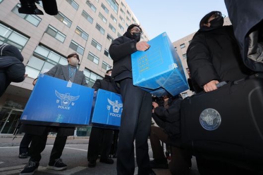 북한의 ‘한국발 무인기 침투’ 주장을 수사하는 군경합동조사티에프 관계자들이 21일 피의자 장아무개씨와 오아무개씨가 다니던 서울의 한 사립대학교 공대 건물에서 압수품을 옮기고 있다. 연합뉴스