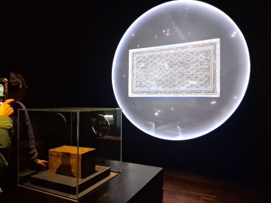 고려 나전상자 진열장 뒤쪽의 미디어스크린에 상자 내부를 엑스선으로 투과한 이미지가 비치고 있다. 가늘고 휜 금속 선으로 상자 전면 국화무늬들 사이를 구획 짓고 장식적 효과도 내고 있음을 보여준다. 노형석 기자