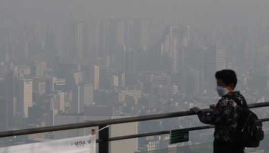 서울 지역 미세먼지가 '나쁨'을 보인 15일 한 시민이 서울 중구 남산에서 뿌연 서울 시내를 내려다 보고 있다. 뉴스1