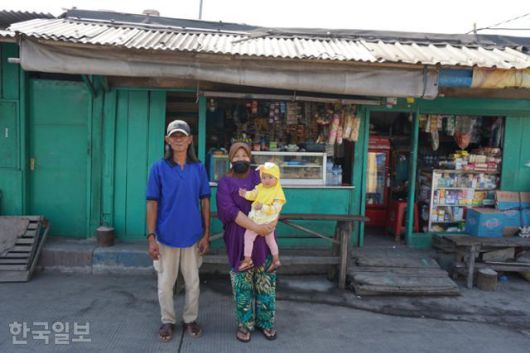 플루이트 마을의 푸르노모씨 가족. 2007년 대홍수로 뒤에 보이는 자신의 가게 지붕까지 잠겼다고 했다. 자카르타=고찬유 특파원