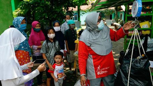 인도네시아 시민단체 림바 푸스타카의 설립자 라덴 로로 헨다르티씨가 주민들에게 책을 빌려주기 위해 쓰레기 무게를 재고 있다. 템포닷코 캡처
