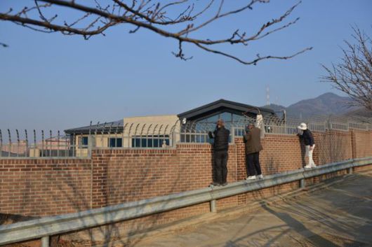 박근혜 전 대통령이 병원 퇴원 후 살 것으로 알려진 대구 달성군 유가읍 쌍계리 한 전원주택 담장 주위에서 지지자들이 건물 내부를 보고 있다. 건물 오른쪽으로 야산으로 올라가는 좁은 도로와 가드레일이 설치돼 있다. 전준호 기자