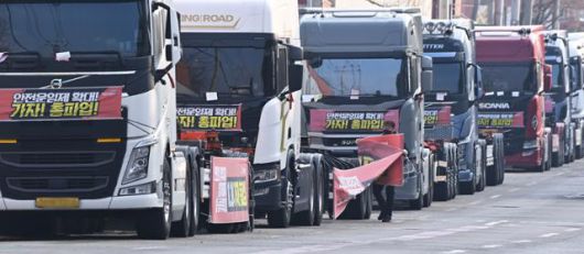 화물연대가 총파업을 철회한 9일 오후 경기도 의왕시 내륙컨테이너기지(ICD)앞 도로에 주차된 화물차에서 한 조합원이 현수막을 철거하고 있다. 의왕=뉴시스